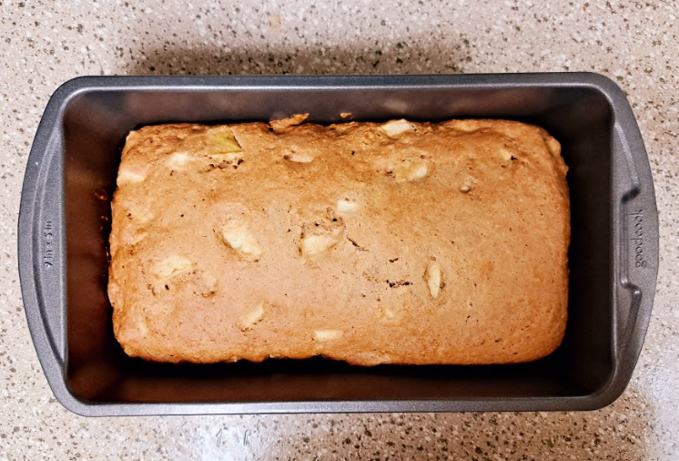 a fully baked apple spice loaf in a dark gray loaf pan
